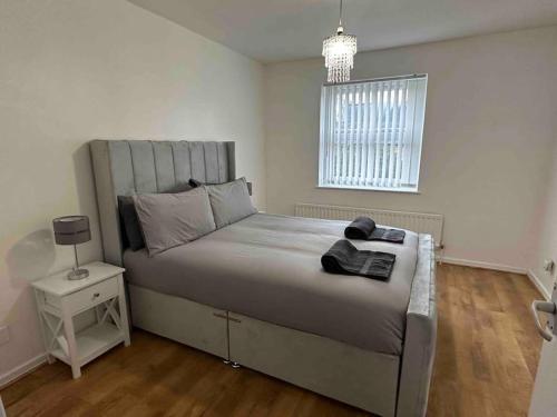 a bedroom with a large bed and a window at NEW! 4 Bedroom London House with Garden and Lawn in London