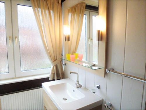 a bathroom with a sink and a mirror and a window at Atlanta Pur in Pellworm