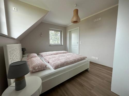 een slaapkamer met een bed met roze lakens en een raam bij Ferienwohnung Oberförstchen in Göda