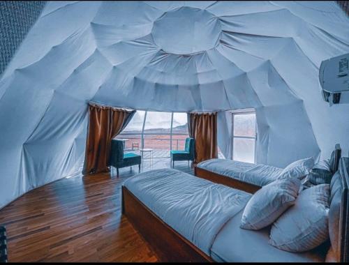 a bedroom with two beds in a tent at Star Guide Camp in Wadi Rum