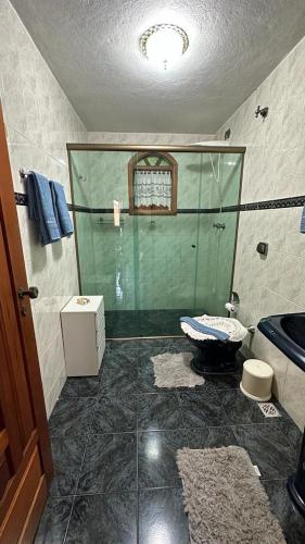 a bathroom with a glass shower and a sink at Casa Ipê in Monte Verde