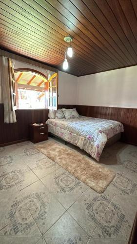 1 dormitorio con 2 camas y ventana en Casa Ipê en Monte Verde