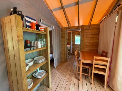 - une salle à manger et une cuisine avec une table et des chaises dans l'établissement Lodges du Bois Dodo - ancien Camping de Bois Redon, à Septfonds