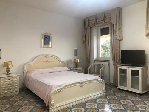 sypialnia z łóżkiem i telewizorem z płaskim ekranem w obiekcie B&B Villa Anna Wunderbar w mieście Ischia