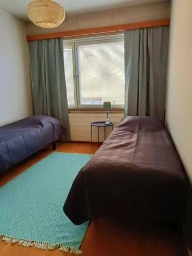 a bedroom with a bed and a window and a rug at Iso kolmio, mahtavalla jokinäkymällä in Joensuu