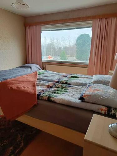 Schlafzimmer mit einem Bett, einem Fenster und einem Tisch in der Unterkunft Iso kolmio, mahtavalla jokinäkymällä in Joensuu