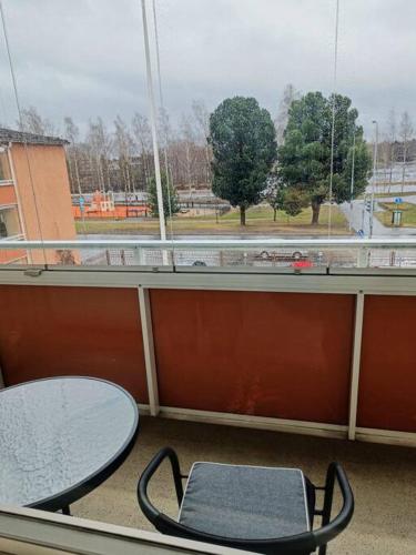 einen Tisch und einen Stuhl vor einem Fenster in der Unterkunft Iso kolmio, mahtavalla jokinäkymällä in Joensuu