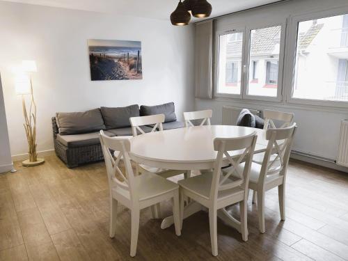 un salon avec une table, des chaises et un canapé dans l'établissement LA CARAVELLE T3 au cœur de ville proche de la plage, à Le Touquet-Paris-Plage
