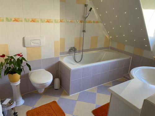 a bathroom with a tub and a toilet and a sink at Pension Evi in Chemnitz