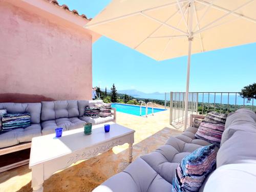 a living room with a couch and an umbrella at Villa Dioni in Fiskardho