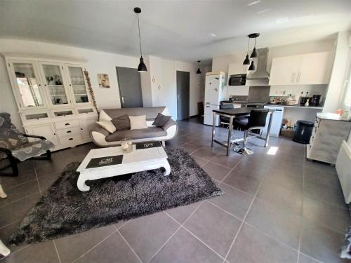 un salon avec un canapé et une table dans l'établissement L'isle sur la sorgue, appartement 2 pièces jardin parking, à LʼIsle-sur-la-Sorgue