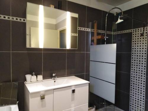 a bathroom with a white sink and a mirror at Maison 4/6 pers avec piscine proche des plages in Sausset-les-Pins
