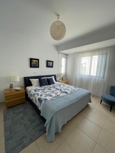 a bedroom with a large bed and a blue chair at Indigo in Protaras