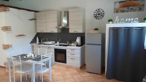 uma cozinha com um frigorífico e uma mesa com cadeiras em Noralù House em Grottaferrata