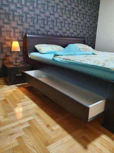 two beds in a room with a wooden floor at Apartman KGC Stara Pazova in Stara Pazova