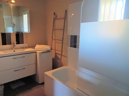 une salle de bain avec un lavabo, une baignoire et un miroir dans l'établissement L'isle sur la sorgue, appartement 2 pièces jardin parking, à LʼIsle-sur-la-Sorgue