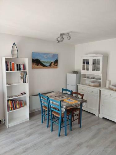 une cuisine avec une table et des chaises dans une pièce dans l'établissement Maison dans résidence calme avec piscine chauffée, à Le Trait dʼUnion