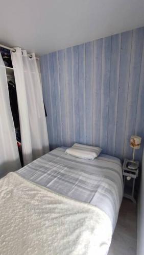- une petite chambre avec un lit à rayures bleues dans l'établissement Maison dans résidence calme avec piscine chauffée, à Le Trait dʼUnion