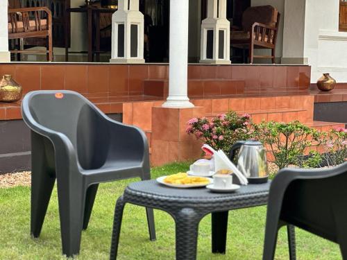 twee stoelen en een tafel met een bord eten erop bij Babira Brookside Heritage Resort in Kumarakom