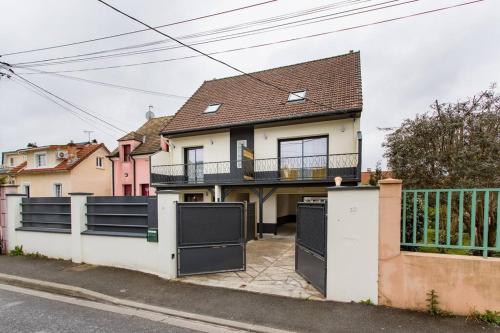 a house with a fence and a balcony at Appartement cosy proche Paris Orly - Climatisé in Morangis