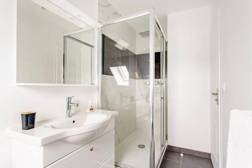 a white bathroom with a sink and a shower at Appartement cosy proche Paris Orly - Climatisé in Morangis