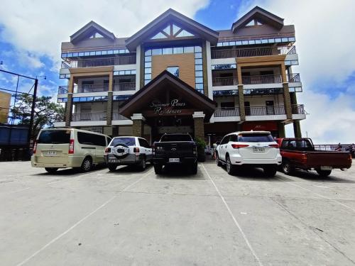 Un estacionamiento con autos estacionados frente a un edificio. en Cozy Millennium House, en Baguio