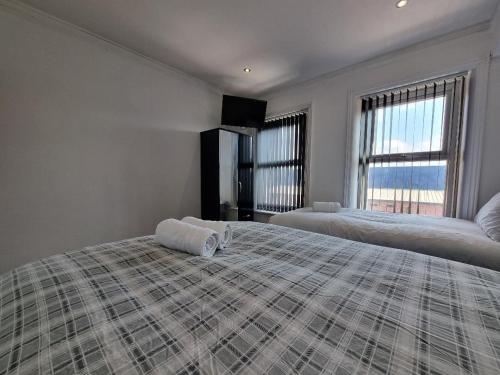a bedroom with two beds and a large window at PL Liverpool in Liverpool