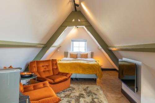 een slaapkamer op zolder met een bed en een stoel bij Cottage Jacob in Zandvoort