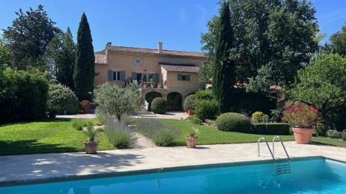 une maison avec une piscine en face d'une cour dans l'établissement Mas Saint-Genies, à Venasque