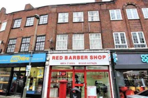 a red barber shop in front of a brick building at Immaculate 1 bedroom apartment in Orpington in Orpington