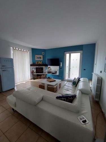 ein Wohnzimmer mit einem weißen Sofa und einem TV in der Unterkunft Casa Ilda in Orta San Giulio