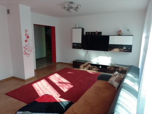 a living room with a couch and a flat screen tv at Dom na Konwaliowej in Narew