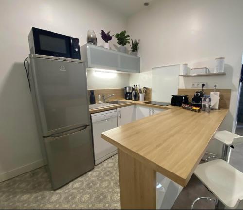 Il comprend une cuisine équipée d'un réfrigérateur et d'une table en bois. dans l'établissement PACA Properties 41H2 - Studio cosy, à Cannes