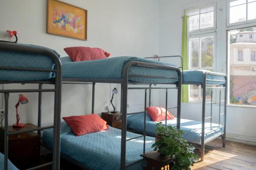 two bunk beds in a room with a window at Casa Volante Hostal in Valparaíso