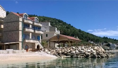a building on the shore of a body of water at Villa Nevia 1 in Drašnice