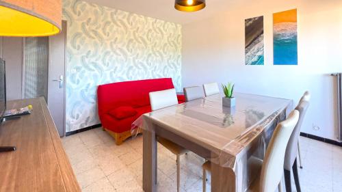 une salle à manger avec une table et une chaise rouge dans l'établissement Appartement lumineux entre plage et montagne, à Banyuls-sur-Mer