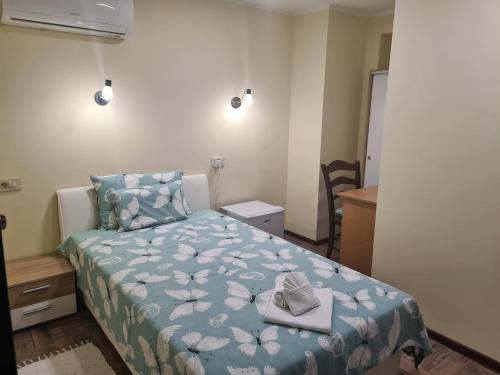 a bedroom with a bed with a blue comforter and two towels at SLATKI SNOVI II in Knin