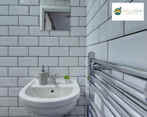 a white bathroom with a sink and a mirror at Special Deal for 5-Bedroom House located near Coventry City Centre and with FREE Netflix Wi-fi and Parking -34HRC in Coventry
