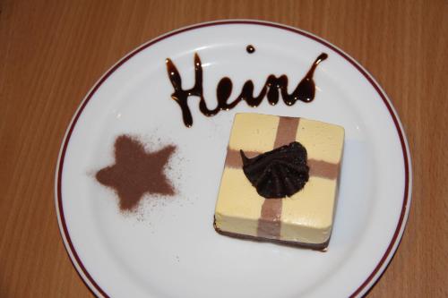 a piece of cake on a white plate with the word hairs at Pension Heino in Saas-Grund