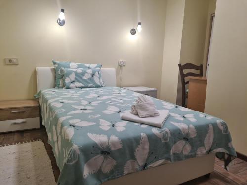 Schlafzimmer mit einem Bett mit blauer Blumenbettdecke in der Unterkunft SLATKI SNOVI II in Knin