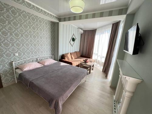 a bedroom with a bed and a couch and a television at Two bedroom apartment in the heart of Chisinau in Chişinău