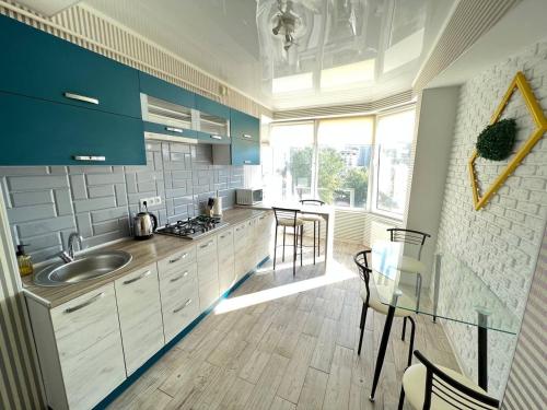 a kitchen with blue cabinets and a sink and chairs at Two bedroom apartment in the heart of Chisinau in Chişinău