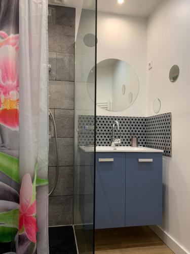a bathroom with a sink and a shower with a mirror at citesteloi in Friville-Escarbotin
