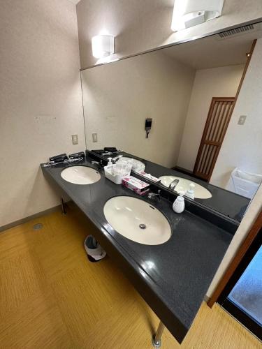a bathroom with two sinks and a large mirror at 【CLUB DEEP BLUE】西伊豆　知る人ぞ知る美しい入江が眺める貸別荘！最大44人宿泊可能！ in Numazu