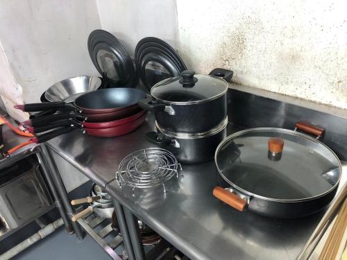 a stove with pots and pans on top of it at 【CLUB DEEP BLUE】西伊豆　知る人ぞ知る美しい入江が眺める貸別荘！最大44人宿泊可能！ in Numazu