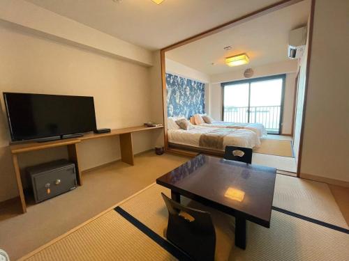 a hotel room with a bed and a television at 【CLUB DEEP BLUE】西伊豆　知る人ぞ知る美しい入江が眺める貸別荘！最大44人宿泊可能！ in Numazu