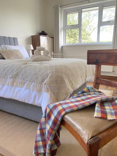 a bedroom with a bed with a blanket on a bench at Benbradagh Country Cottage Causeway Coast in Dungiven