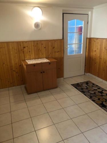 eine Küche mit Tür und Fliesenboden in der Unterkunft Apartmán Skvělá Nálada in Všemyslice