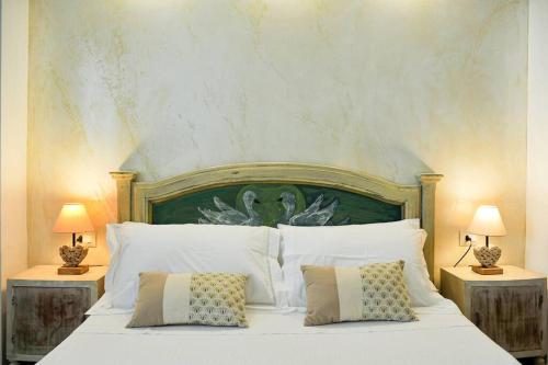 een slaapkamer met een groot wit bed met 2 lampen bij [Sea Front with View] Elegance in Castelsardo