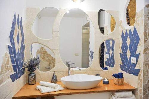een badkamer met een wastafel en een grote spiegel bij [Sea Front with View] Elegance in Castelsardo